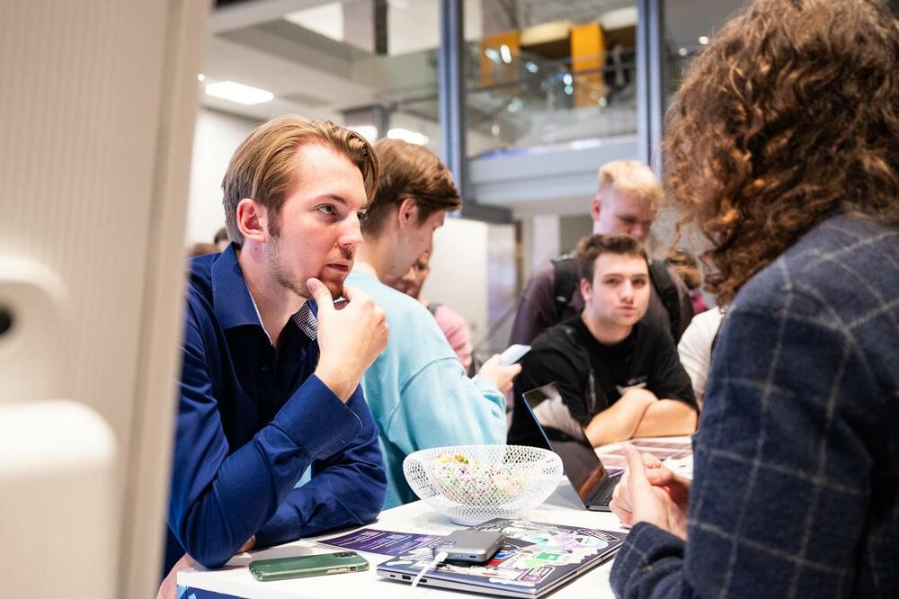 На изображении гости университета перед стойкой Клуба предпринимательства МИСИС