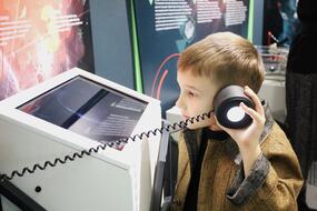 Ребёнок взаимодействует с экспонатом в зале «Космос. Вселенная. Жизнь» центра «Выставка «Железно!»