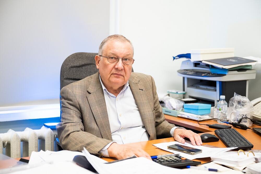 Игорь Блинков сидит за рабочим столом, портретное фото